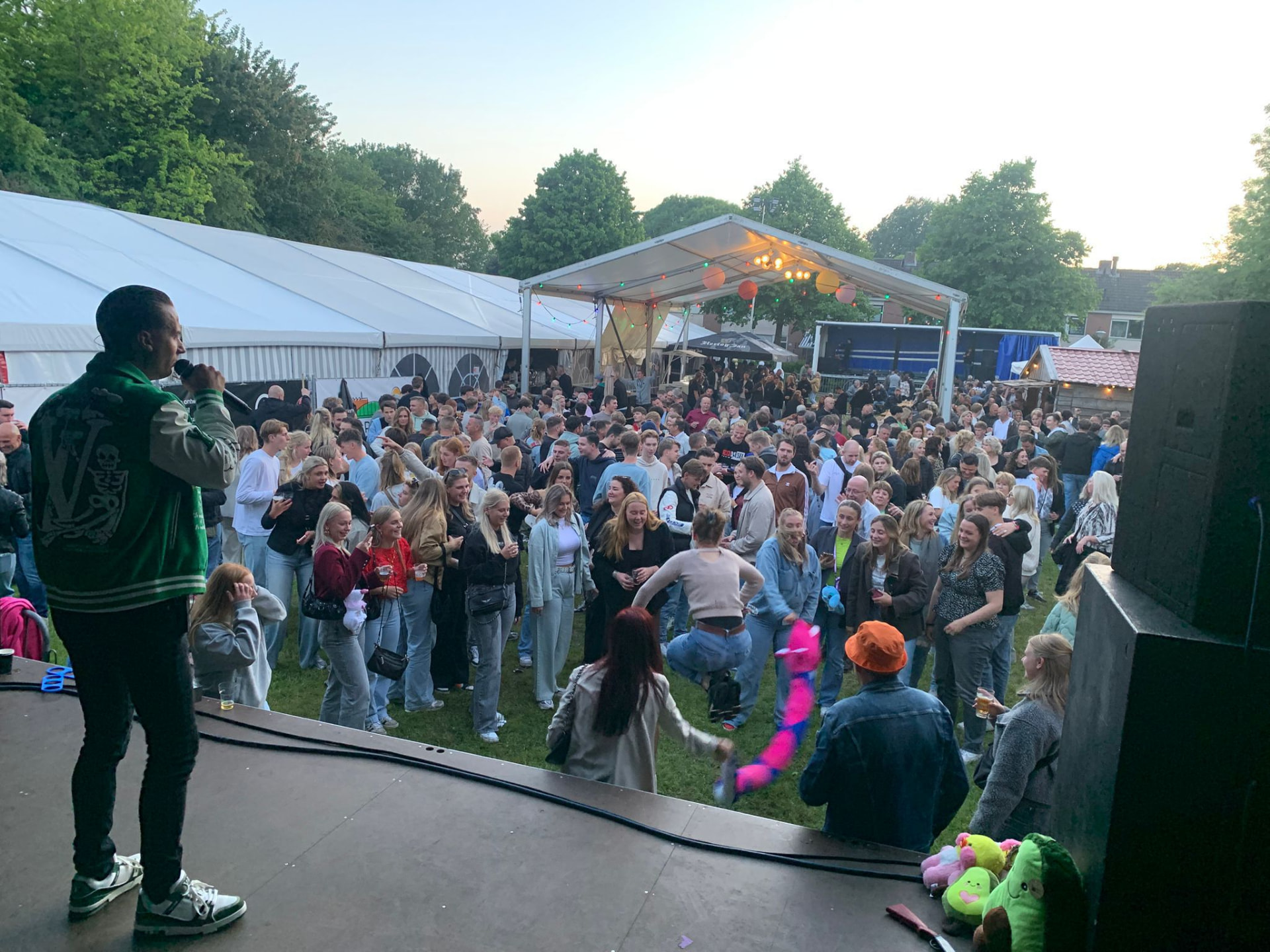 Jermaine Stuiver treedt op voor een groot dansend publiek op een buitenpodium